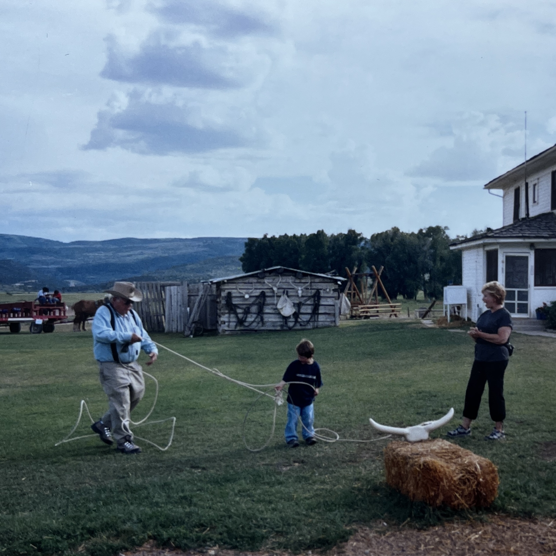 Grandpa teaching a young Cam to rope at a ranch